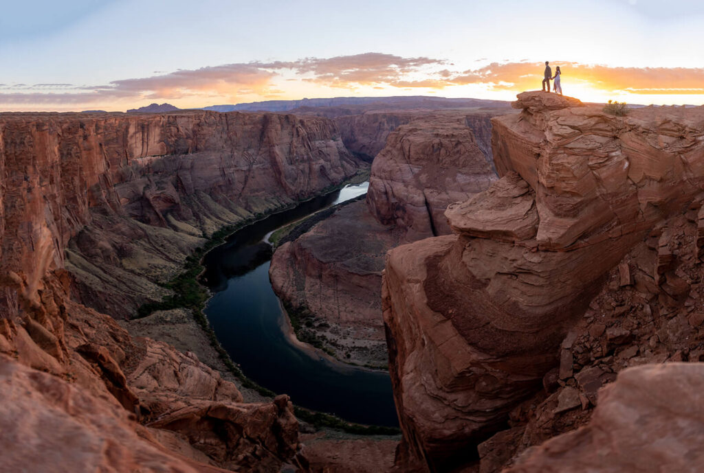 couple on red rock cliff edge at Horseshoe Bend in Arizona